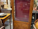 une armoire avec une porte vitrée au milieu d'une pièce