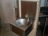 a sink in the corner of a kitchen with a door open