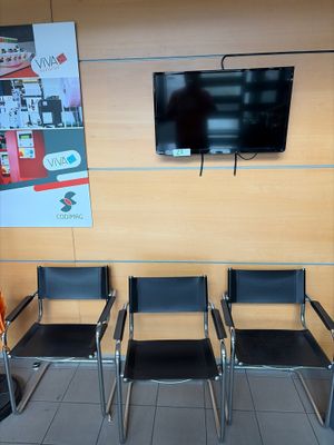 quatre chaises dans une salle d'attente avec une télévision accrochée au mur