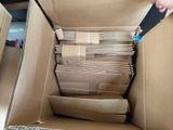 a person holding a pair of scissors in a cardboard box