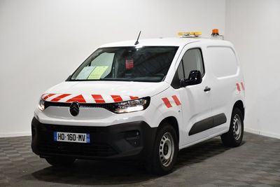 la camionnette blanche est garée dans une grande pièce au sol en damier