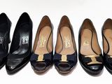 quatre paires de chaussures noires ornées de nœuds sont alignées sur une surface blanche