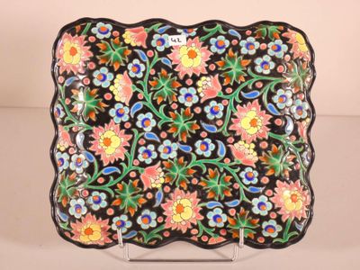 a close up of a black plate with colorful flowers on it