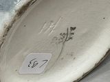 a close up of a vase with a tag on it