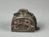 un vieux porte-monnaie en argent, muni d'une chaîne, posé sur une table