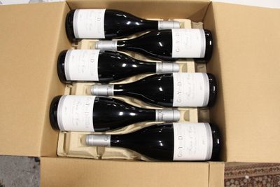 six bouteilles de vin dans un carton posé par terre