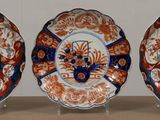 three plates on display on a table with a wall in the background