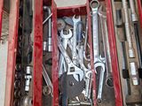 de nombreux outils dans une boîte à outils rouge posée par terre