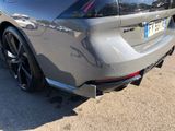 the rear end of a silver sports car parked on the side of the road