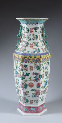 un vase blanc orné de motifs colorés sur un fond gris
