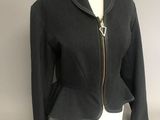 the jacket is black and has a gold zipper on the front