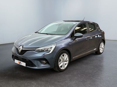 Une voiture grise est garée dans une pièce au sol noir.