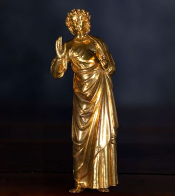 statue en or représentant une femme tenant une bougie sur une table en bois