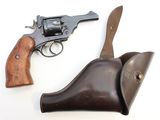 un vieux revolver et un étui en cuir posés sur une surface blanche