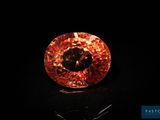 gros plan d'un diamant orange sur une surface noire