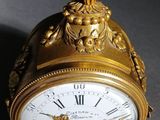 a gold clock with a snake on top of it