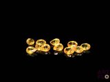 two yellow glass beads are sitting on a black surface