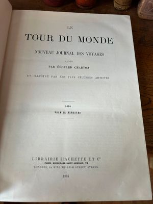 un livre ouvert posé sur une table en bois, à côté d'une tasse de café