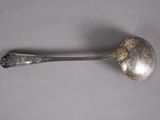 a silver spoon with a spoon handle on a table