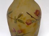 a yellow vase with flowers painted on it on a white background