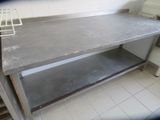 a metal work table with a basket on top of it