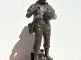 statue en bronze représentant un garçon avec un livre et un cartable