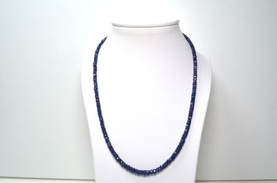 collier composé de perles de verre bleues sur un mannequin blanc