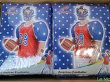 two boxes of american football cards are in a cardboard box