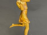 a statue of a woman holding a tennis racquet on a marble base