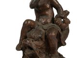 statue en bronze représentant un garçon assis sur un rocher avec un chien