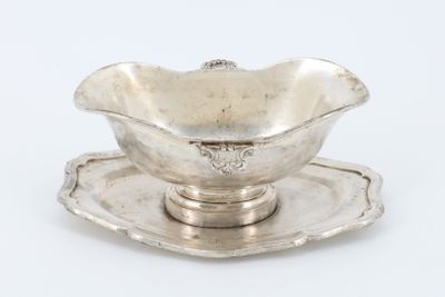 un service ancien en argent composé d'un bol et d'une soucoupe posés sur une soucoupe