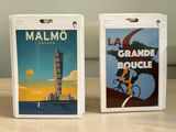 two boxes of cigarettes sitting on a table with a clock tower in the background
