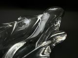 a glass sculpture of a dolphin on a black surface
