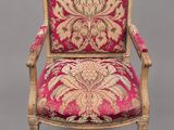 un fauteuil rembourré rose et doré, orné d'un motif floral