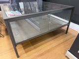 a glass coffee table with a magazine on top of it