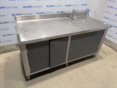 un évier en acier inoxydable dans une pièce avec un mur bleu en arrière-plan