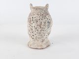 a small white owl figurine sitting on a white surface
