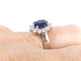 a close up of a person ' s hand with a diamond and sapphire ring