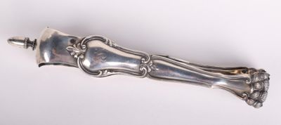 une cuillère en argent avec un manche sur une surface blanche