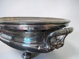 an antique silver plate with handles and handles on a stand