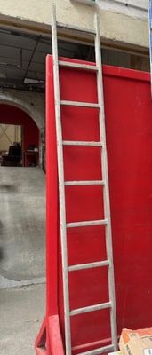 une échelle appuyée contre un mur rouge dans un garage