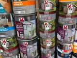 several cans of paint are stacked on top of each other