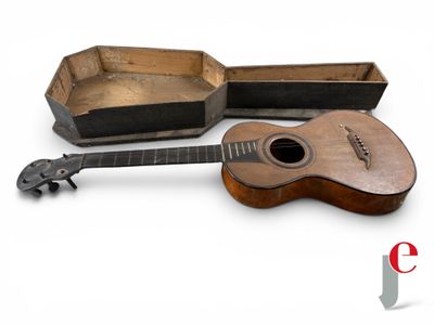 une guitare et une boîte posées sur une surface blanche