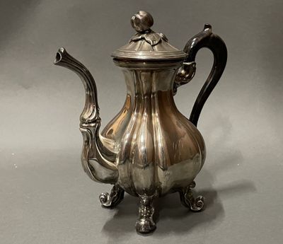 une théière en argent surmontée d'un oiseau