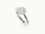 gros plan d'une bague en diamant et émeraude sur fond blanc