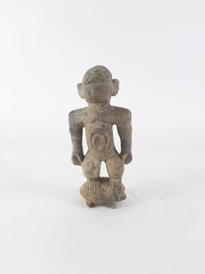 an old figurine of a man standing on a white surface