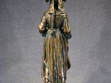 bronze statue of a woman with a hat on her head