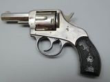 an old revolver is sitting on a white surface with a black handle