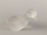 a white glass bird that is sitting on a table