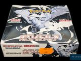 the box is full of pokemon cards on display in a dark room